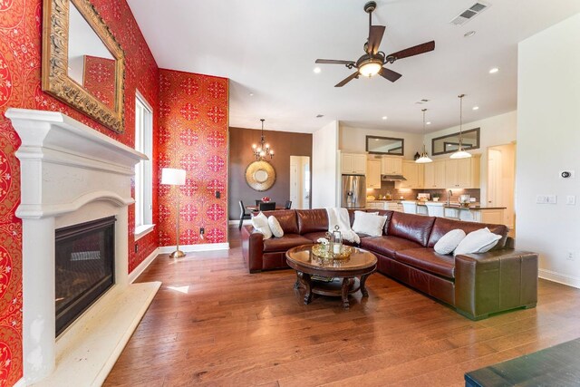 1821 Gilded Crest Dr, Leander, TX 78641 - living room featuring wallpapered walls, hardwood / wood-style floors, ceiling fan, a fireplace, and recessed lighting