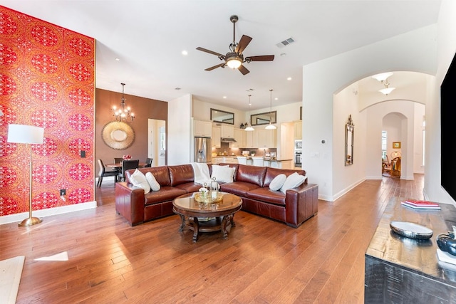 1821 Gilded Crest Dr, Leander, TX 78641 - living room with arched walkways, ceiling fan, light wood-type flooring, recessed lighting, and a chandelier