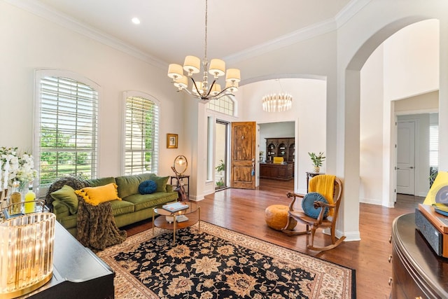 1821 Gilded Crest Dr, Leander, TX 78641 - living area featuring a chandelier, wood finished floors, crown molding, and arched walkways