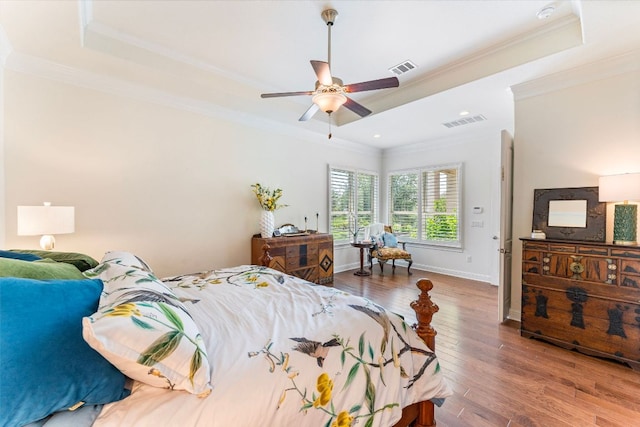 1821 Gilded Crest Dr, Leander, TX 78641 - bedroom featuring crown molding, a raised ceiling, wood finished floors, and a ceiling fan