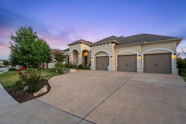 1821 Gilded Crest Dr, Leander, TX 78641 - mediterranean / spanish-style house with stucco siding, an attached garage, driveway, a front lawn, and a shingled roof