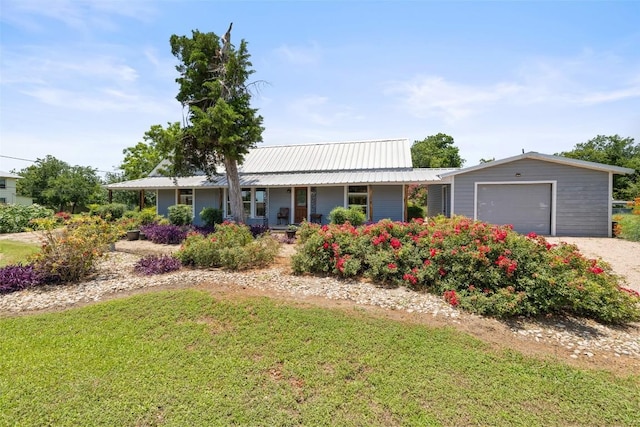 104 S 1st St, Thorndale, TX 76577 - ranch-style house with a front lawn, a metal roof, gravel driveway, and a garage