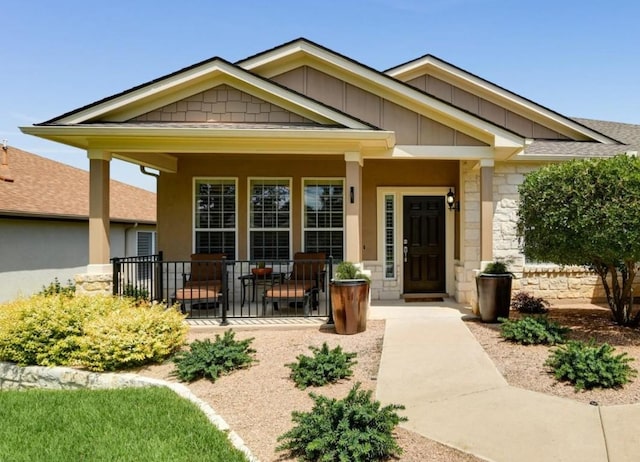 203 Mustang Island Trl, Georgetown, TX 78633 - view of exterior entry featuring a porch, stone siding, and board and batten siding