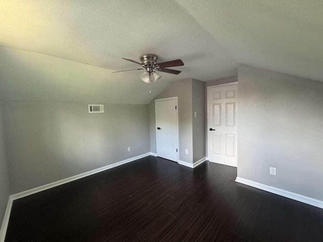 6609 Capriola Dr, Austin, TX 78745 - bonus room featuring a ceiling fan, vaulted ceiling, dark wood-type flooring, and a textured ceiling