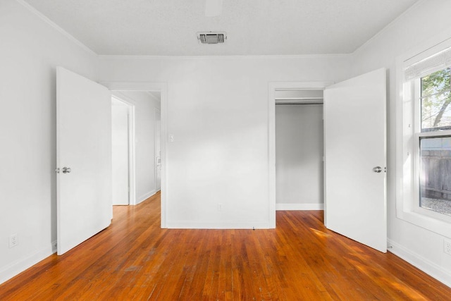 506 W 51st St Unit A, Austin, TX 78751 - unfurnished bedroom featuring crown molding, wood finished floors, and a closet
