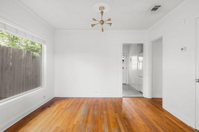 506 W 51st St Unit A, Austin, TX 78751 - spare room with hardwood / wood-style flooring, a chandelier, and a textured ceiling