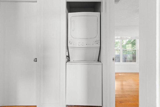 506 W 51st St Unit A, Austin, TX 78751 - laundry room featuring stacked washer / dryer, wood finished floors, and a textured ceiling