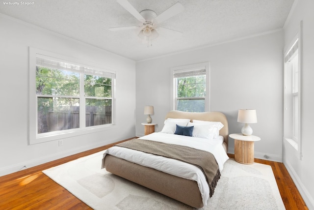 506 W 51st St Unit A, Austin, TX 78751 - bedroom with wood finished floors, ornamental molding, a textured ceiling, and ceiling fan