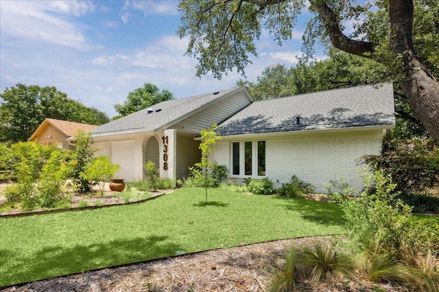 11308 Toledo Dr, Austin, TX 78759 - view of front of house featuring an attached garage, brick siding, a front lawn, and a shingled roof