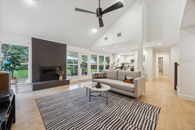11308 Toledo Dr, Austin, TX 78759 - living area featuring a brick fireplace, a ceiling fan, high vaulted ceiling, and light wood-type flooring