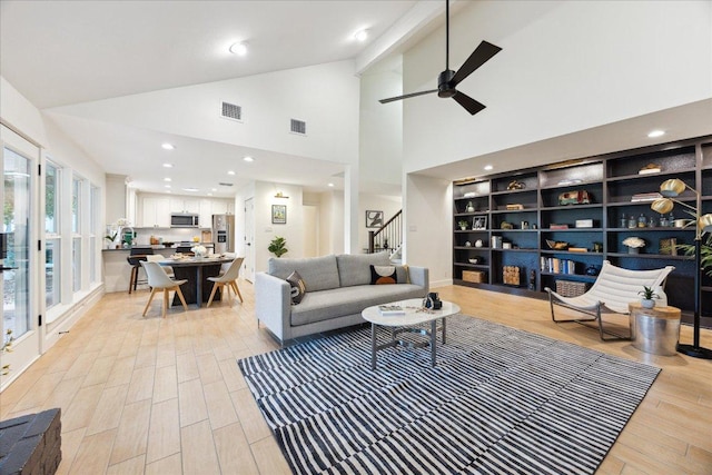 11308 Toledo Dr, Austin, TX 78759 - living room with ceiling fan, light wood-style flooring, high vaulted ceiling, stairway, and recessed lighting
