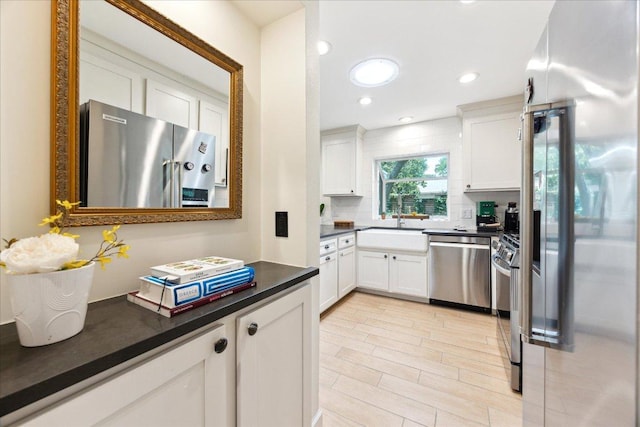 11308 Toledo Dr, Austin, TX 78759 - kitchen featuring appliances with stainless steel finishes, dark countertops, backsplash, white cabinetry, and recessed lighting