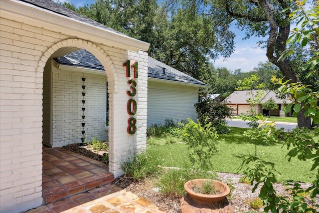 11308 Toledo Dr, Austin, TX 78759 - doorway to property featuring brick siding, a shingled roof, and a lawn
