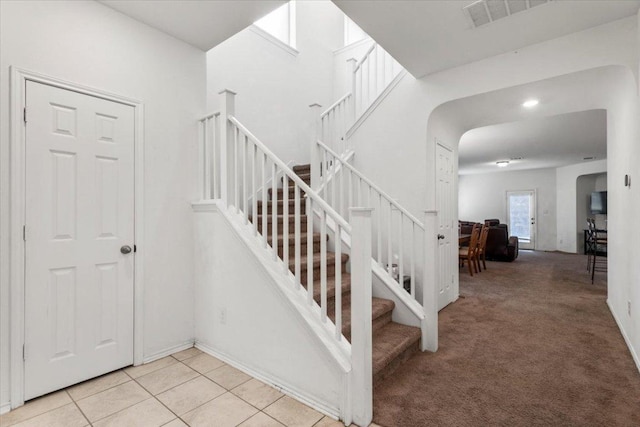 239 Crimson Ln, Kyle, TX 78640 - stairs featuring arched walkways, tile patterned floors, and carpet