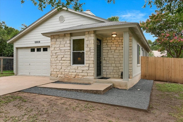 12806 Heinemann Dr, Austin, TX 78727 - view of front of property with stone siding, concrete driveway, and an attached garage