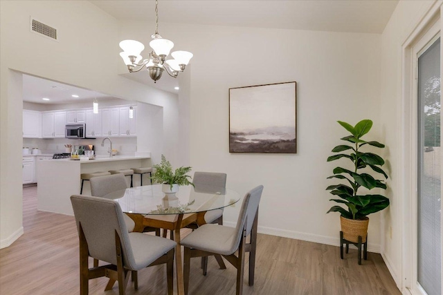 12806 Heinemann Dr, Austin, TX 78727 - dining area featuring light wood-style floors and a chandelier