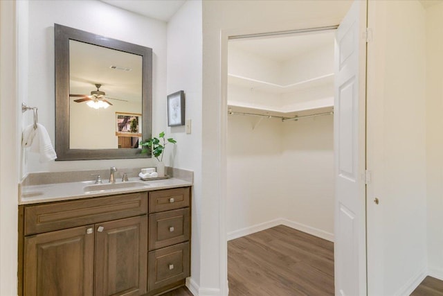 12806 Heinemann Dr, Austin, TX 78727 - bathroom featuring vanity, wood finished floors, a ceiling fan, and a spacious closet