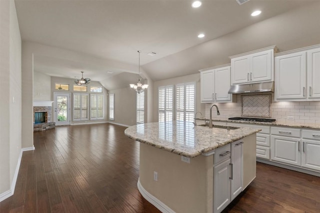 7901 Arbor Knoll Ct, Lago Vista, TX 78645 - kitchen featuring under cabinet range hood, open floor plan, vaulted ceiling, a chandelier, and plenty of natural light