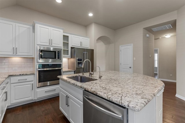 7901 Arbor Knoll Ct, Lago Vista, TX 78645 - kitchen with appliances with stainless steel finishes, white cabinets, dark wood-style flooring, backsplash, and light stone countertops