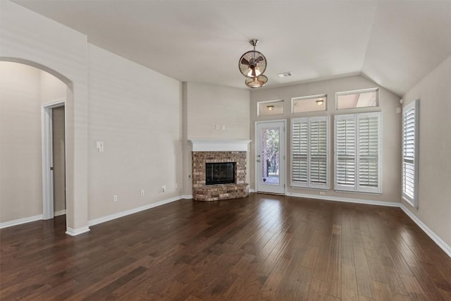 7901 Arbor Knoll Ct, Lago Vista, TX 78645 - unfurnished living room with dark wood finished floors, a fireplace, arched walkways, and vaulted ceiling