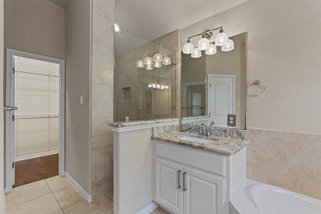 7901 Arbor Knoll Ct, Lago Vista, TX 78645 - full bath featuring a walk in shower, vanity, tile patterned flooring, a garden tub, and a walk in closet