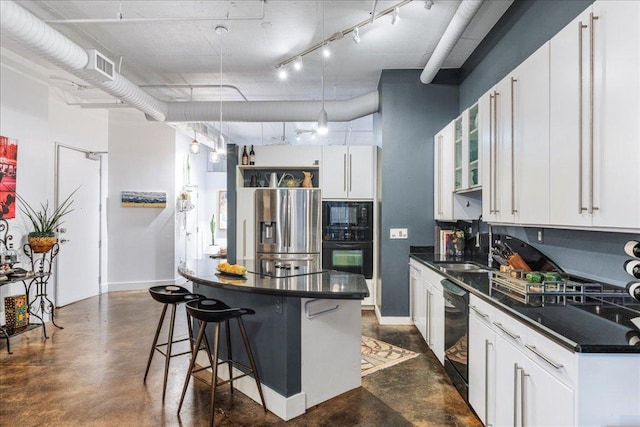 311 W 5th St Unit 1008, Austin, TX 78701 - kitchen with black appliances, dark countertops, concrete floors, a kitchen bar, and white cabinetry