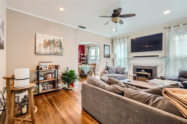 1508 Pease Rd, Austin, TX 78703 - living room featuring arched walkways, a ceiling fan, wood finished floors, crown molding, and a high end fireplace