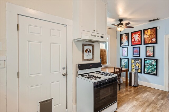 1508 Pease Rd, Austin, TX 78703 - kitchen featuring white gas range, under cabinet range hood, ceiling fan, white cabinetry, and light wood-type flooring