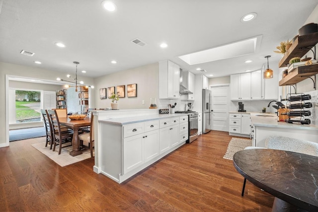 8714 Silverhill Ln, Austin, TX 78759 - kitchen featuring appliances with stainless steel finishes, wall chimney range hood, dark wood finished floors, open shelves, and white cabinets