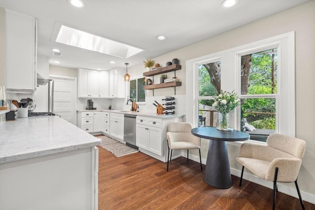 8714 Silverhill Ln, Austin, TX 78759 - kitchen featuring stainless steel dishwasher, a skylight, white cabinetry, dark wood finished floors, and recessed lighting