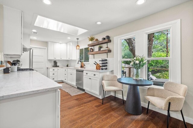 8714 Silverhill Ln, Austin, TX 78759 - kitchen featuring stainless steel dishwasher, a skylight, white cabinetry, dark wood-style floors, and recessed lighting