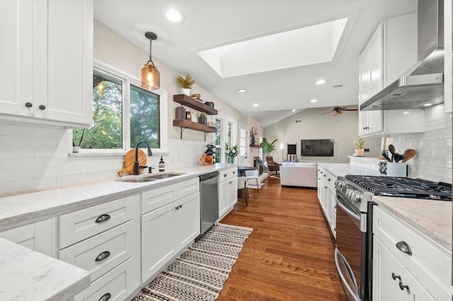8714 Silverhill Ln, Austin, TX 78759 - kitchen with appliances with stainless steel finishes, wall chimney range hood, a skylight, backsplash, and white cabinets