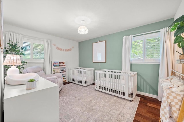 8714 Silverhill Ln, Austin, TX 78759 - bedroom featuring wood finished floors and a nursery area