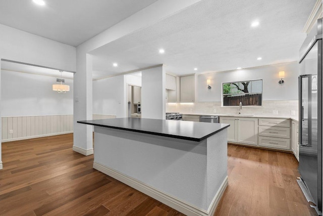406 N Coronado Dr, Kerrville, TX 78028 - kitchen featuring wood finished floors, appliances with stainless steel finishes, decorative backsplash, a kitchen island, and recessed lighting