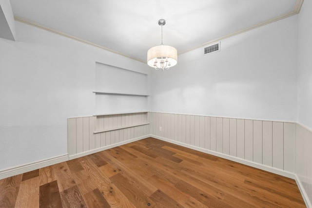 406 N Coronado Dr, Kerrville, TX 78028 - unfurnished room with wood finished floors, a chandelier, crown molding, and a wainscoted wall