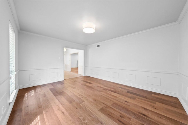 406 N Coronado Dr, Kerrville, TX 78028 - empty room featuring plenty of natural light, wood finished floors, crown molding, a decorative wall, and wainscoting