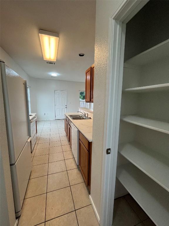 3016 Aftonshire Way, Austin, TX 78748 - kitchen featuring white appliances, light countertops, light tile patterned floors, and brown cabinets