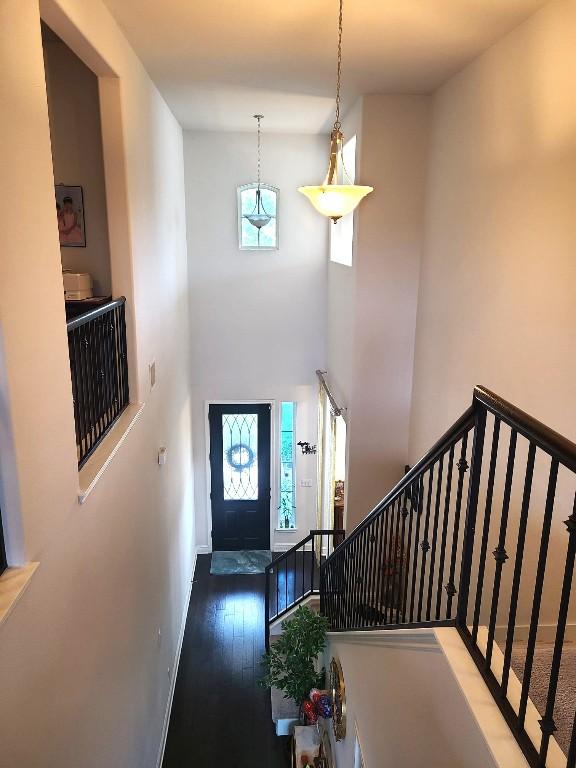 608 Cascada Ln, Round Rock, TX 78681 - entrance foyer with wood finished floors, a towering ceiling, and stairway