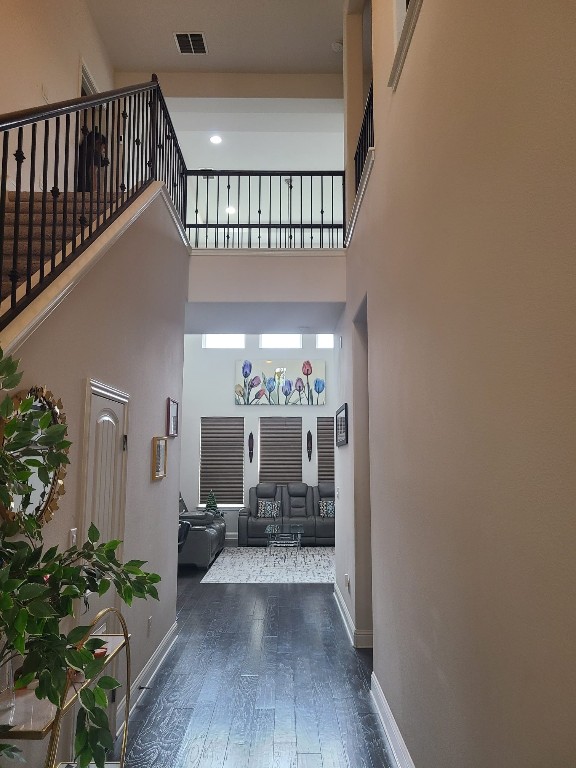 608 Cascada Ln, Round Rock, TX 78681 - corridor featuring wood finished floors, a high ceiling, and stairs