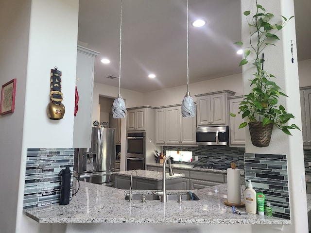 608 Cascada Ln, Round Rock, TX 78681 - kitchen featuring stainless steel appliances, gray cabinets, tasteful backsplash, a peninsula, and light stone countertops