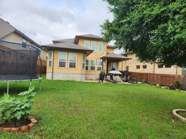 608 Cascada Ln, Round Rock, TX 78681 - rear view of property featuring a trampoline, a fenced backyard, and a shingled roof
