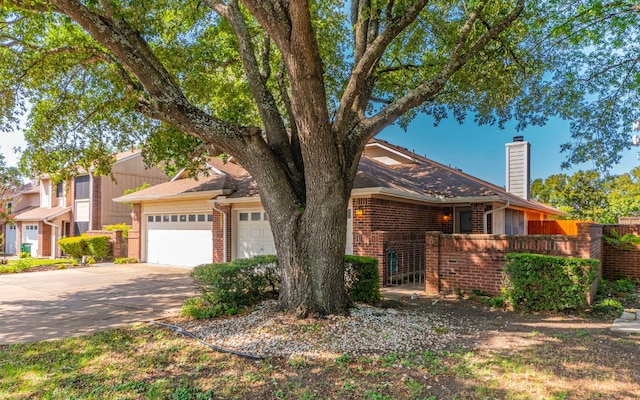 1007 Markham Ln Unit A, Austin, TX 78753 - view of front of property featuring a chimney, concrete driveway, brick siding, and an attached garage