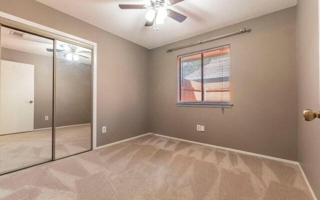 1007 Markham Ln Unit A, Austin, TX 78753 - unfurnished bedroom featuring carpet, a closet, a textured ceiling, and ceiling fan