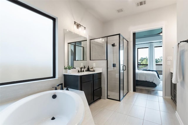 2624 San Bautista Way Unit 44, Leander, TX 78641 - ensuite bathroom featuring a stall shower, a garden tub, vanity, and tile patterned floors