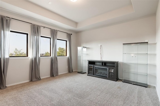 2624 San Bautista Way Unit 44, Leander, TX 78641 - unfurnished living room featuring carpet, a fireplace, and a tray ceiling