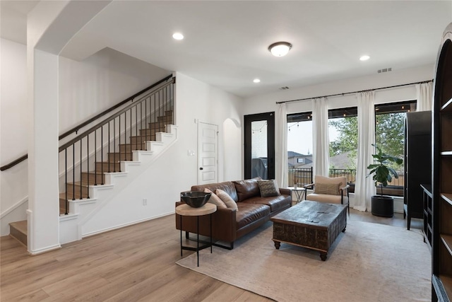 2624 San Bautista Way Unit 44, Leander, TX 78641 - living room with stairway, light wood-style flooring, arched walkways, and recessed lighting