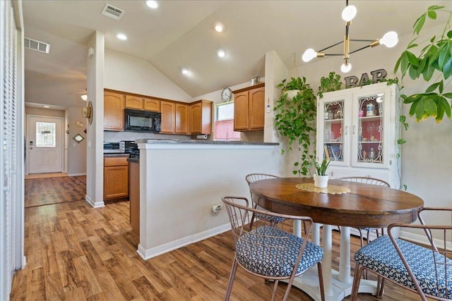 2321 Kale Dr, Austin, TX 78725 - dining room featuring light wood-style floors, lofted ceiling, healthy amount of natural light, recessed lighting, and a chandelier