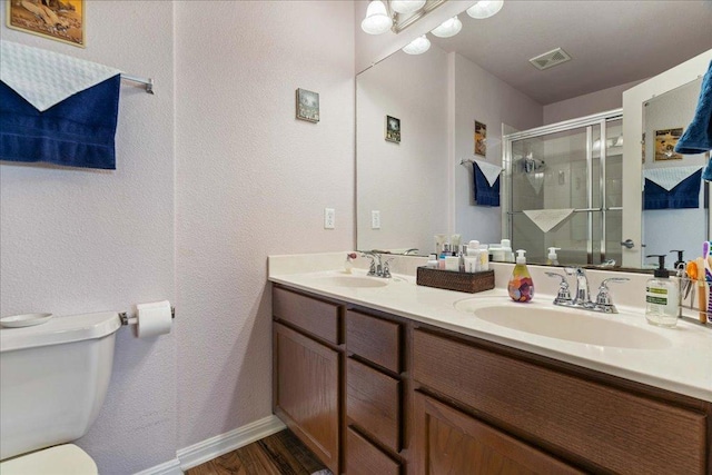 2321 Kale Dr, Austin, TX 78725 - bathroom featuring a stall shower, double vanity, a textured wall, and wood finished floors