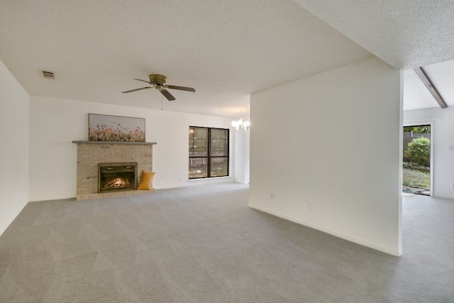 8702 Wildridge Dr, Austin, TX 78759 - unfurnished living room featuring a ceiling fan, carpet, a fireplace, a textured ceiling, and a chandelier