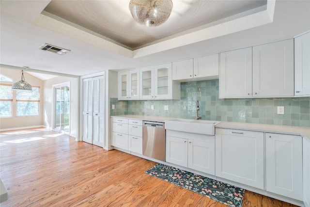 7507 Valburn Dr, Austin, TX 78731 - kitchen featuring dishwasher, a raised ceiling, light wood finished floors, light countertops, and tasteful backsplash
